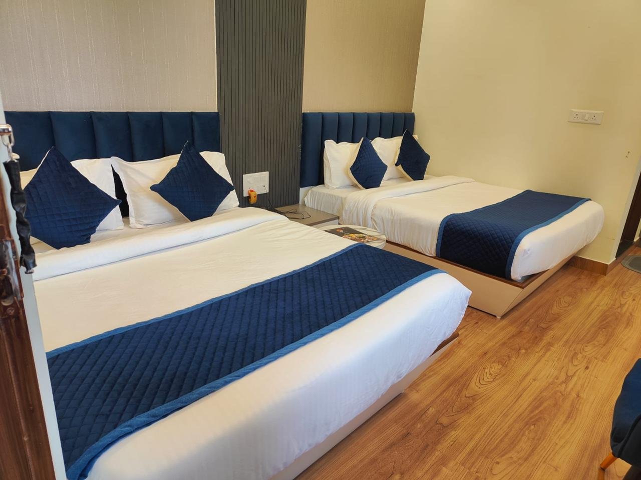 Royal Suite with king size bed, golden accents, bedside lamps, classic furnishings, and floor-to-ceiling curtains overlooking a private balcony at The Ummed Ahmedabad